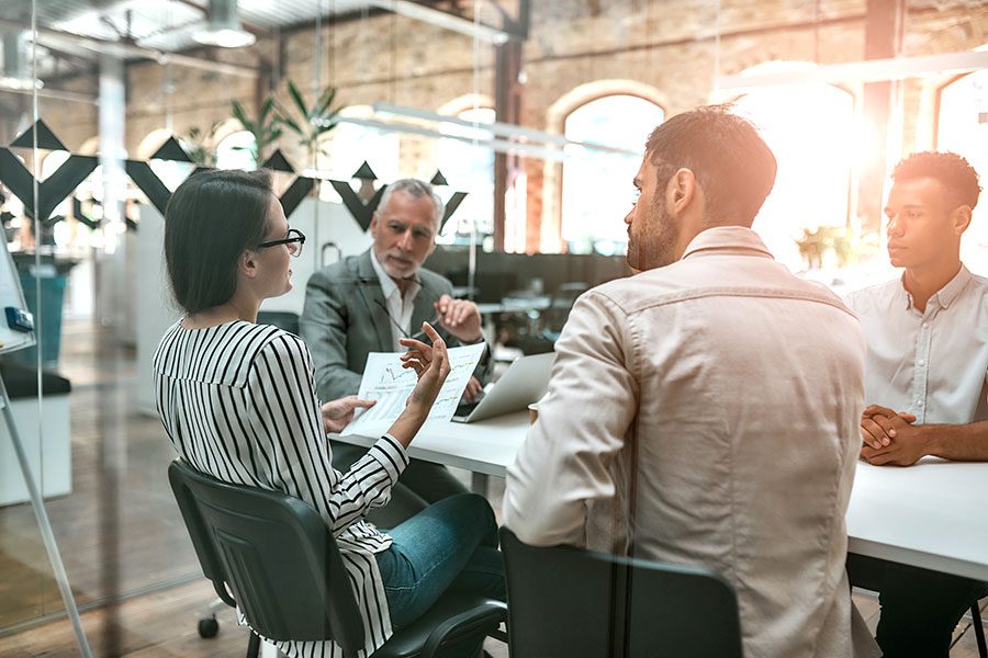 About Us - Business Employees in Meeting Room in Modern Ofifice at Desk Talking